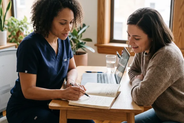 Nurse practitioner reviewing a symptom diary with a patient during an LDI consultation